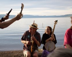 Jesting pirates by the lake shore with toy weapons charging musicians holding their instruments