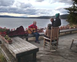Musicians on a porch overlooking the lake