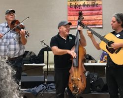 Band with fiddle, bass, and guitar performing
